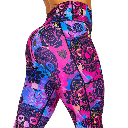 close up back view of purple, pink and blue tie dye leggings with black skull and rose pattern