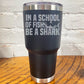 30oz black tumbler with silver saying "in a school of fish be a shark" with a shark cartoon over the word "fish"
