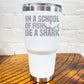 30oz white tumbler with silver saying "in a school of fish be a shark" with a shark cartoon over the word "fish"