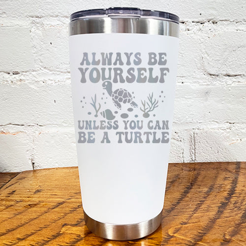 20oz white tumbler with silver saying "always be yourself unless you can be a turtle" with turtle cartoon, seaweed, shells and bubbles