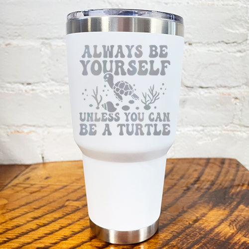 30oz white tumbler with silver saying "always be yourself unless you can be a turtle" with turtle cartoon, seaweed, shells and bubbles