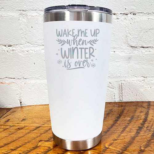20oz white tumbler with silver saying "wake me up when winter is over" with mini snowflakes around it