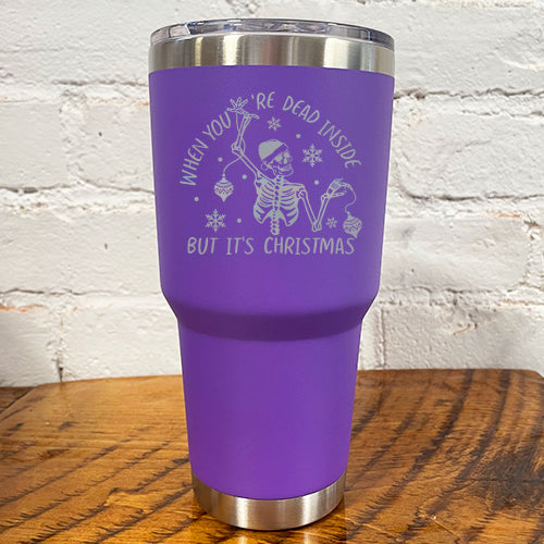  30oz purple tumbler with silver saying "when you're dead inside but it's christmas" with a santa hat skeleton holding ornaments